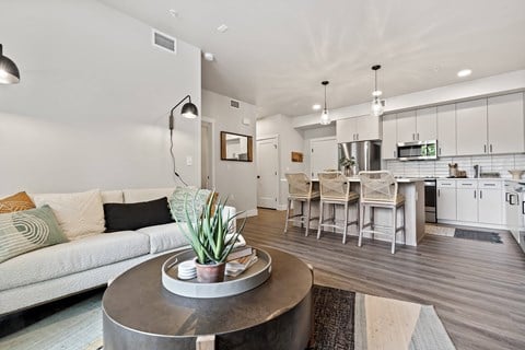 a living room and kitchen with a couch and a table